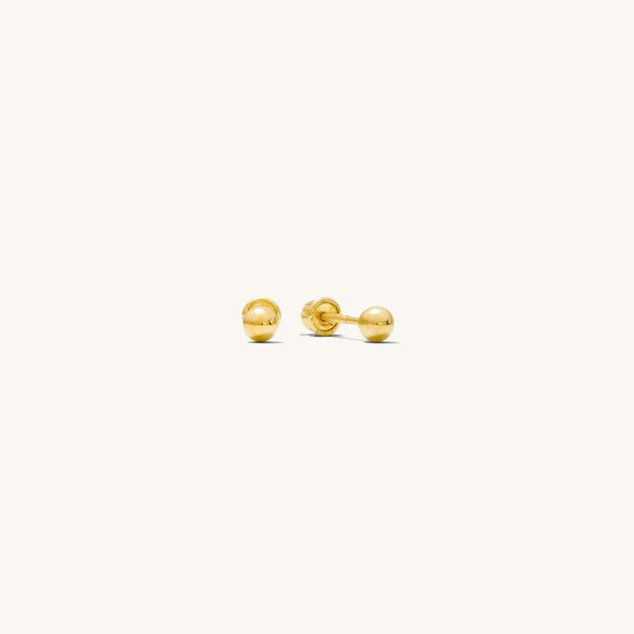 Close up of gold stud earrings on a white background