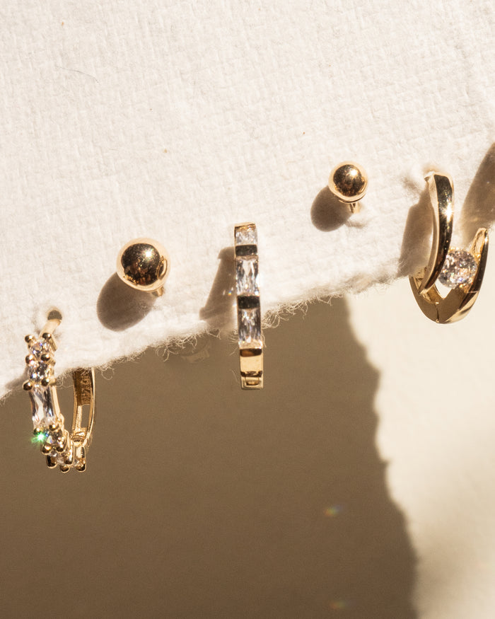 Mixed gold earrings on a fabric card
