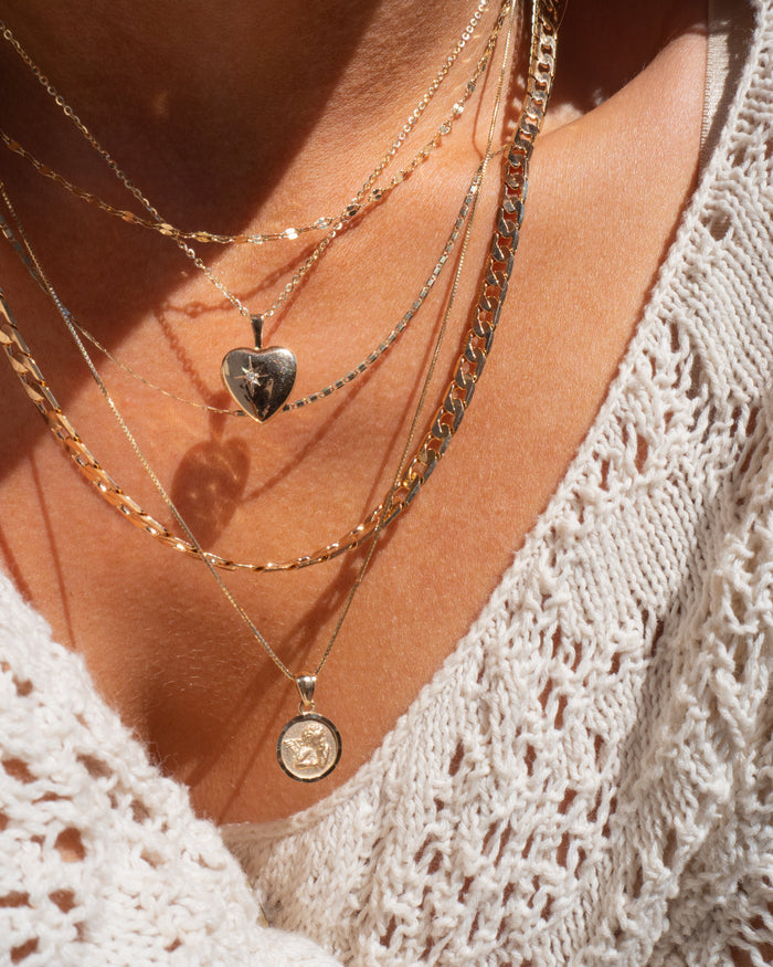 Model wearing the gold Cherub pendant as an elegant everyday necklace
