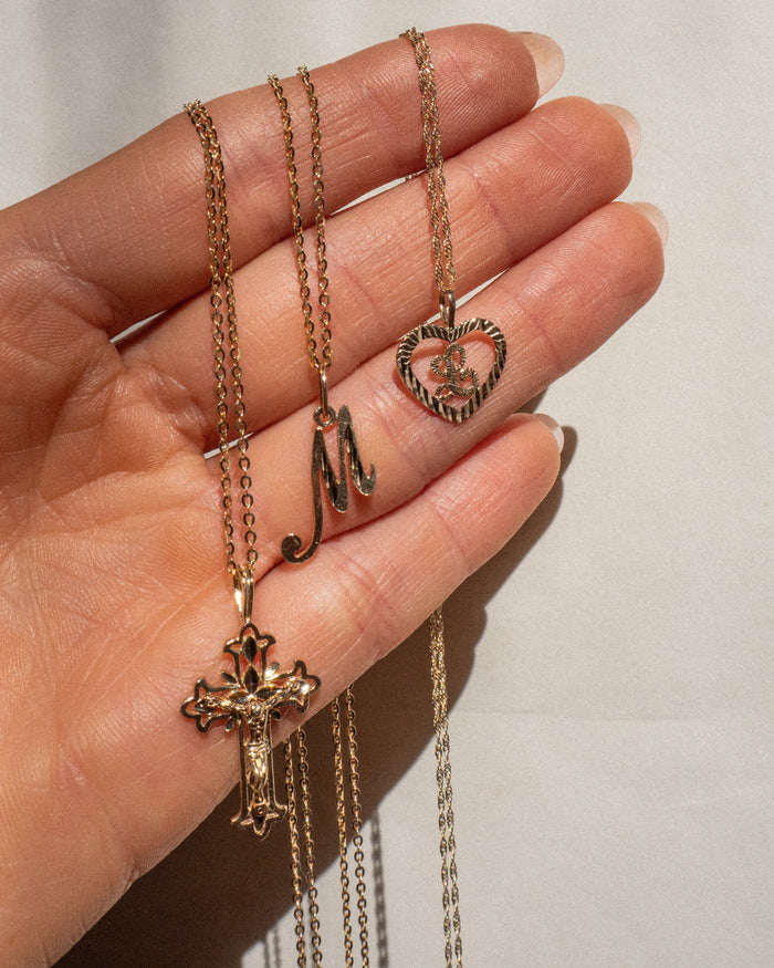 Model wearing the cutout heart initial pendant of the Corazon necklace