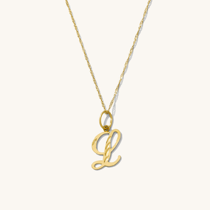 The Cursive initial necklace with a diamond-cut solid gold letter