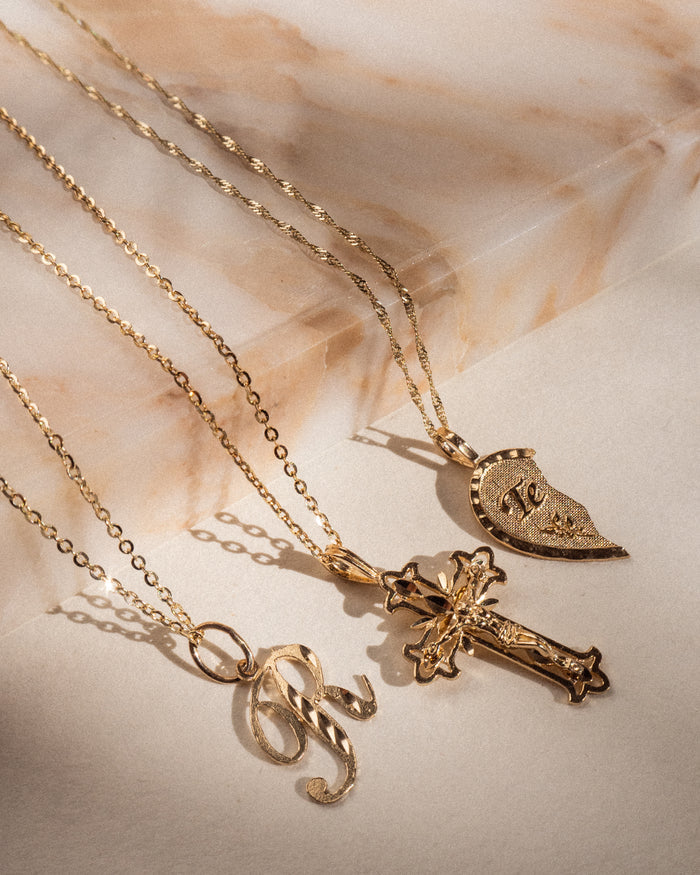 Model wearing the script initial pendant of the Cursive necklace in gold