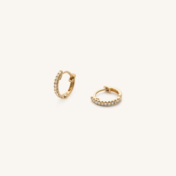 Close up of an ear wearing the 14k diamond Stella huggie earring
