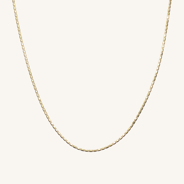 Close up of the 14k gold Disco Tile chain necklace on a white background