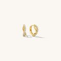 Close up of gold hoops with stones on a white background