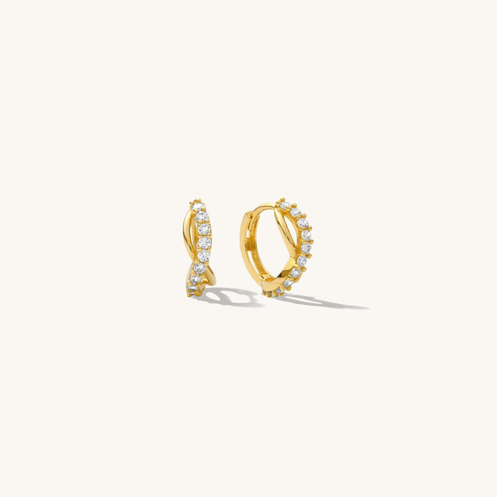 Close up of gold hoops with stones on a white background