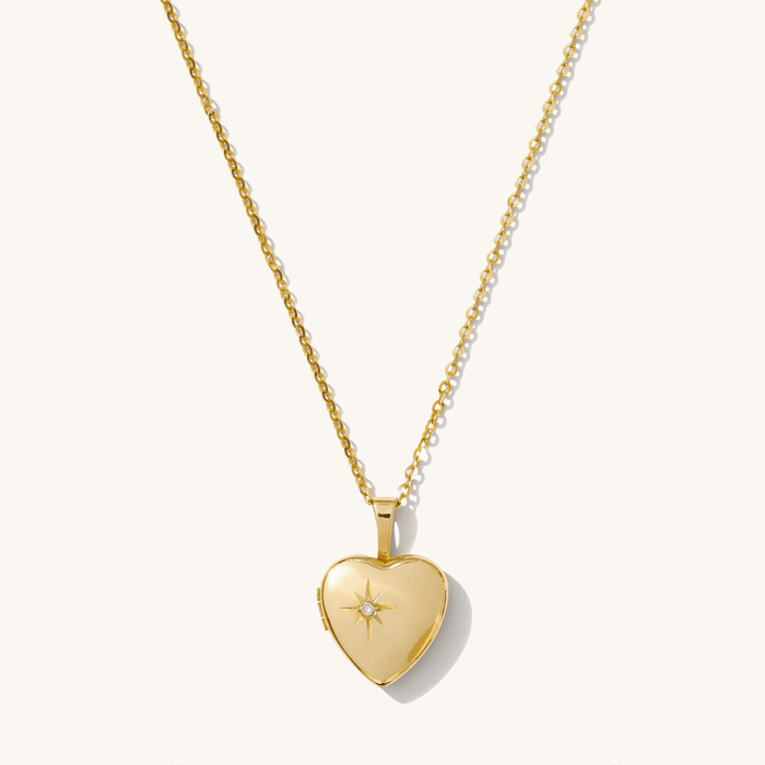The Love Locket necklace, a heart-shaped 14k gold locket with a CZ starburst