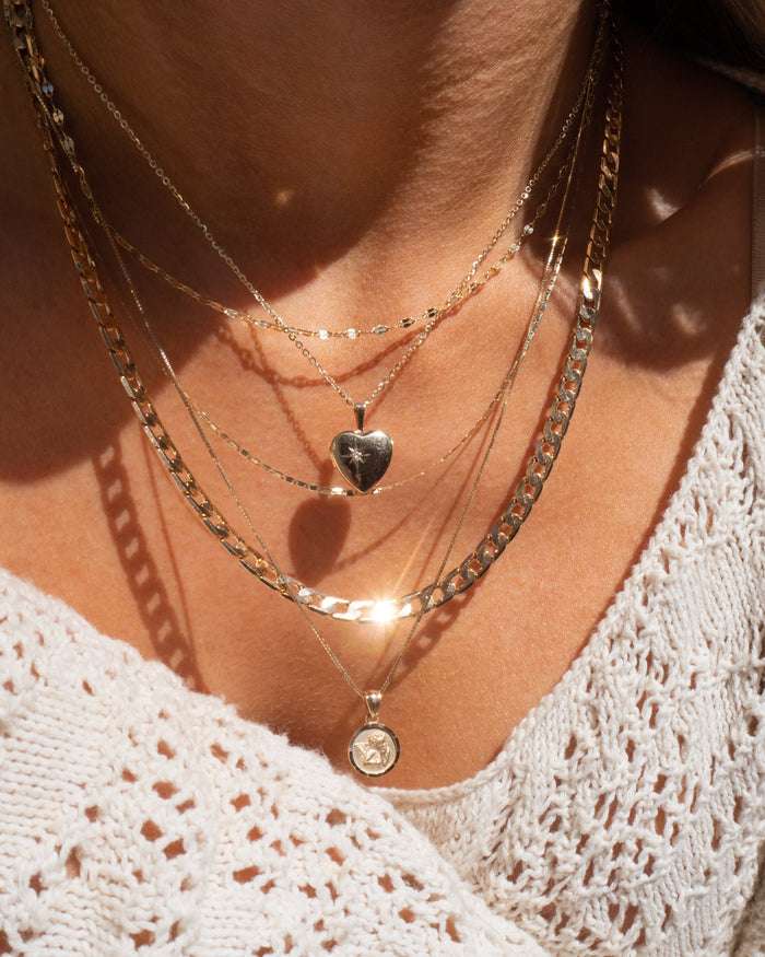 Model wearing the gold Love Locket heart pendant at the neckline
