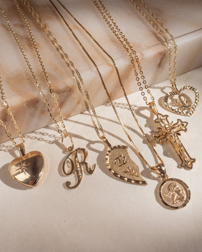 Model wearing the Love Locket necklace layered with dainty gold chains