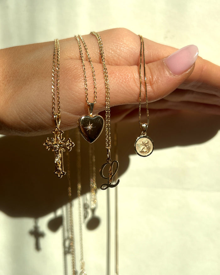Model wearing the gold Love Locket near the collarbone on a fine chain