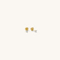 Close up of gold stud earrings on a white background