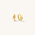 Close up of gold hoops with stones on a white background