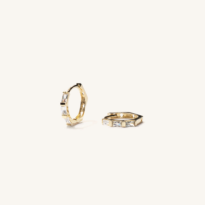 Close up of gold earrings with stones on a white background