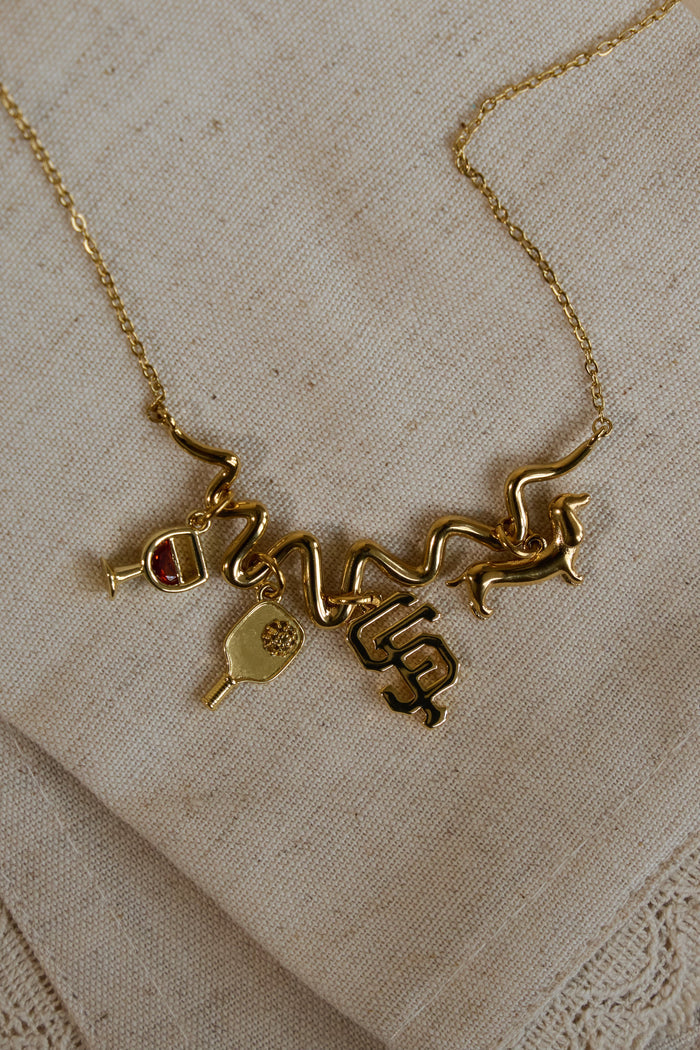 Model wearing the gold Contour charm necklace with a charm added