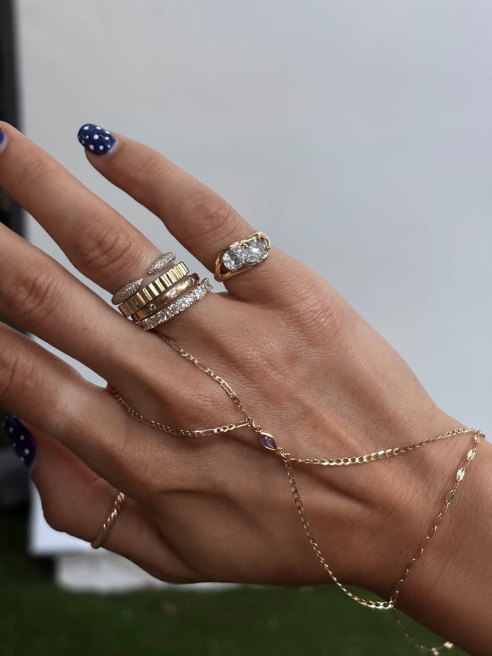 A gold double pear pinky ring set with two facing pear cut stones