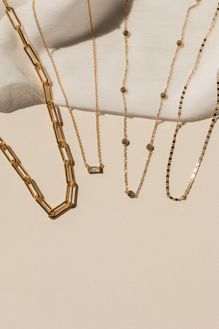 Gold necklaces displayed on a white surface