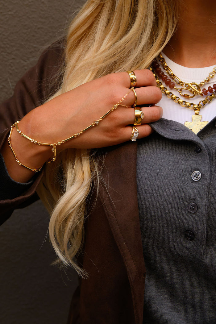 The Anna bezel ring, a polished gold band set with three sparkling stones