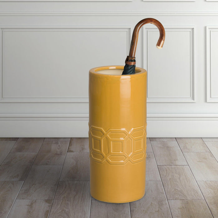 Yellow umbrella stand with a wooden handle against a white paneled wall. - The Well Appointed House