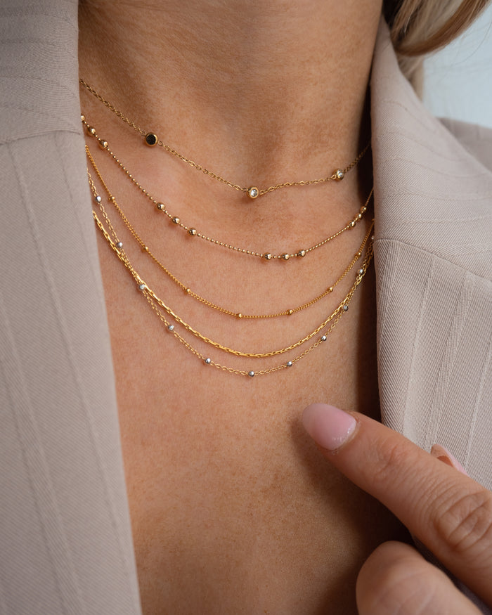 Model wearing the gold Azin necklace with its dainty bead accents