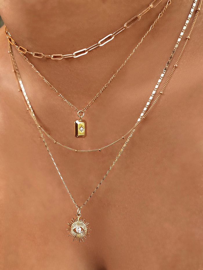 Azin necklace worn layered with other minimalist gold chains