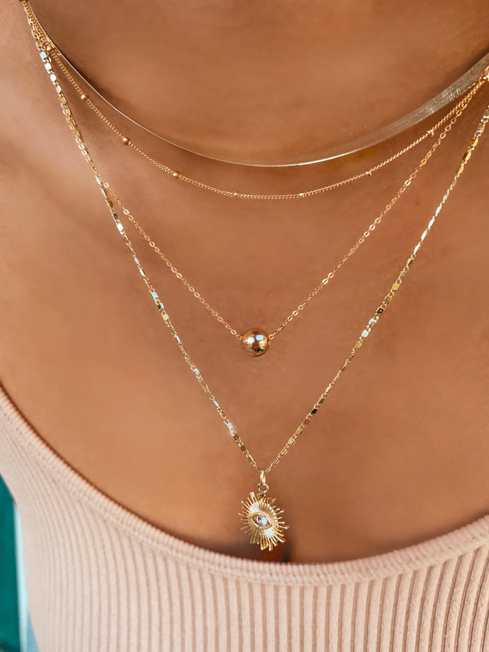 The Azin necklace styled on the neckline as a beginner layering piece