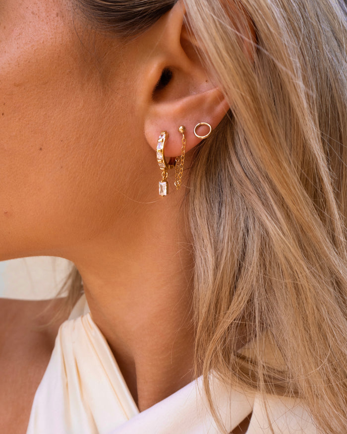 Close-up of an ear with multiple gold earrings