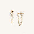 Close up of gold ball stud earrings with chain attachment