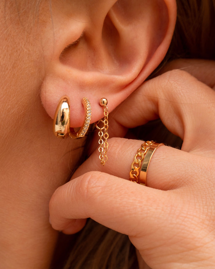 Close-up of an ear with multiple gold earrings