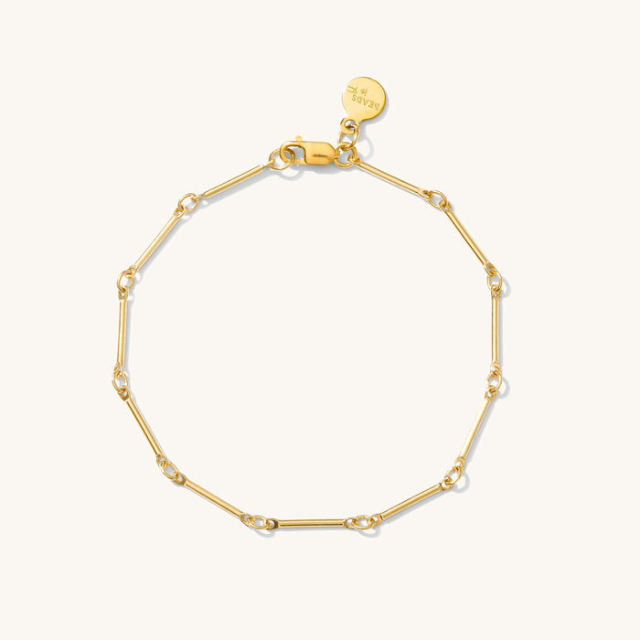 Close up of a gold bracelet on a white background