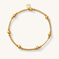 Close up of a gold bead bracelet on a white background