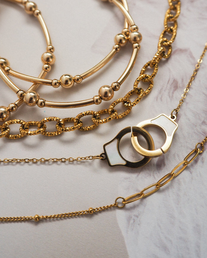 Assorted gold jewelry laid on a white surface