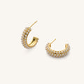 Close up of gold hoops with pearl accents on a white background