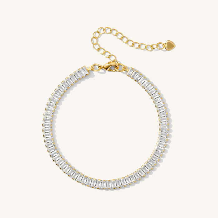 Close up of a gold baguette tennis bracelet on a white background