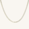 Close up of the gold Bellini tennis necklace on a white background