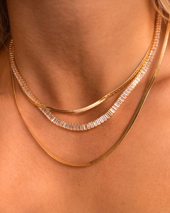 Close up of a neckline wearing the Bellini emerald-cut tennis necklace