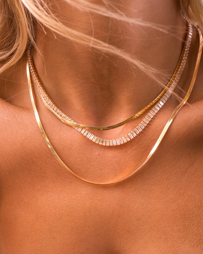 Close up of a neckline wearing the sparkling gold Bellini necklace