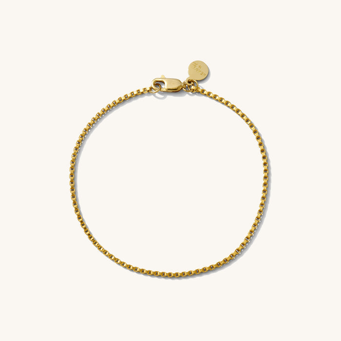 Close up of a gold chain bracelet on a white background