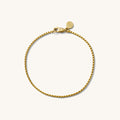 Close up of a gold chain bracelet on a white background