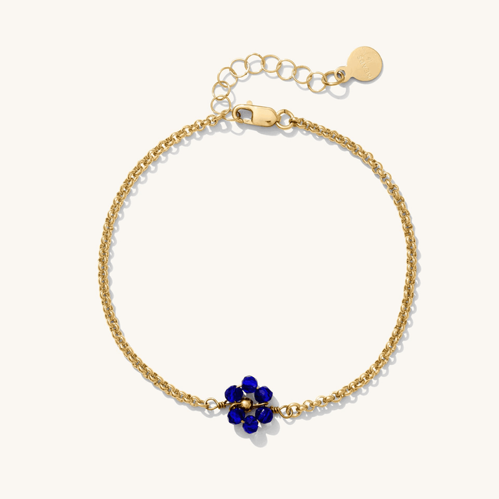 Close up of gold bracelets with colored birthstones