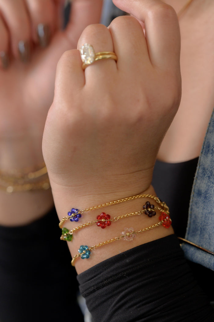 Close up of a hand with gold and stone bracelets and rings