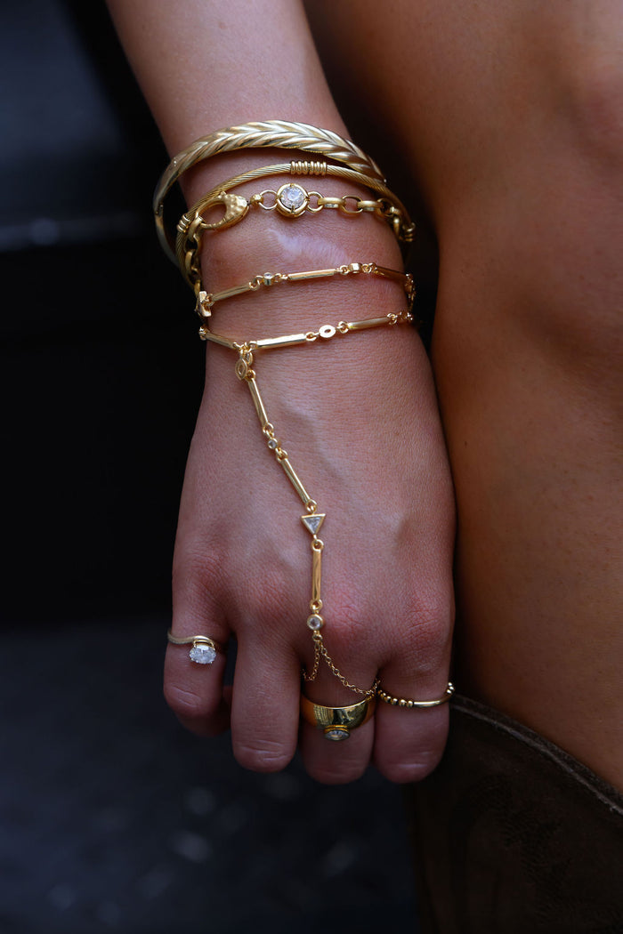 A wrist with gold rings and bracelets
