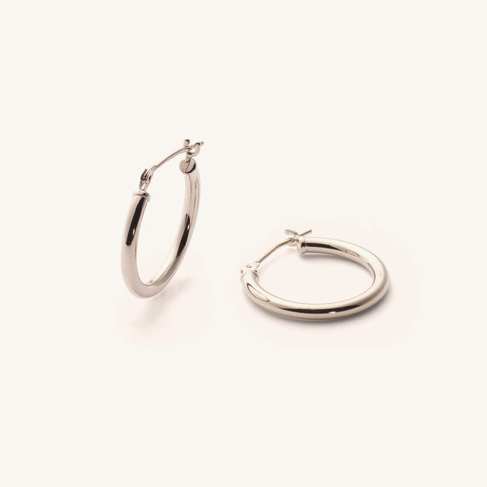 Close up of silver hoop earrings on a white background