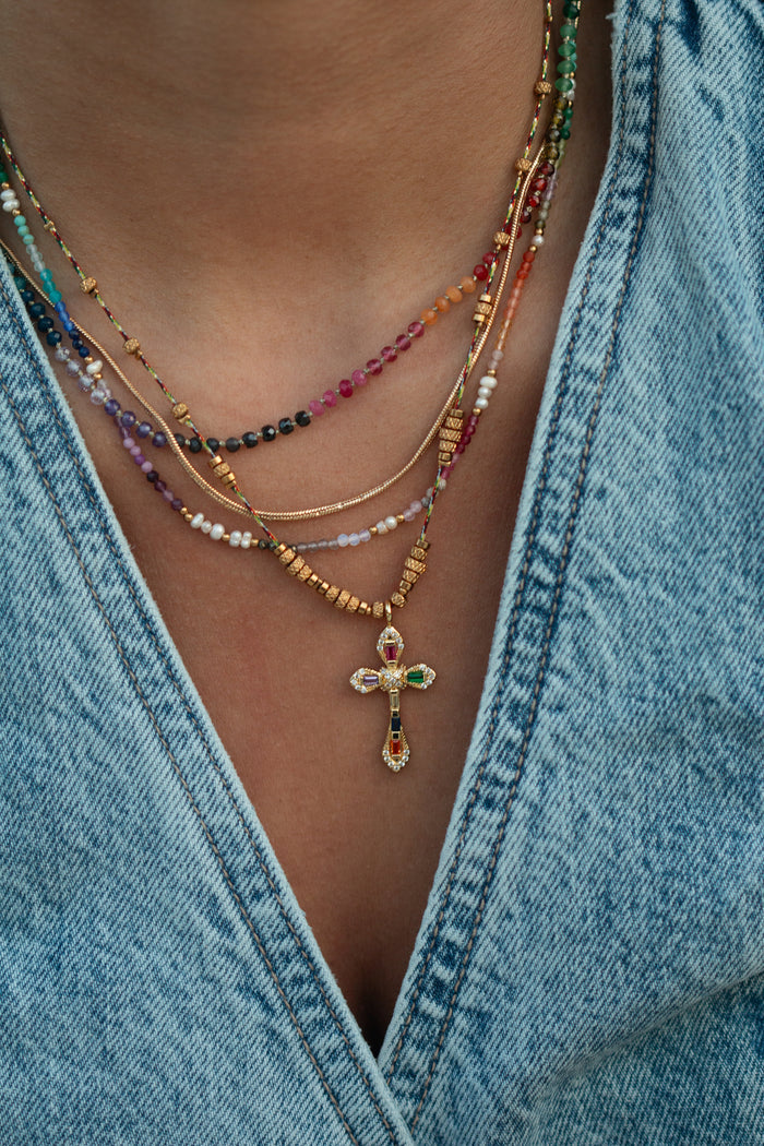 The Caliente cross necklace, set with jewel-tone stones and gold bead accents