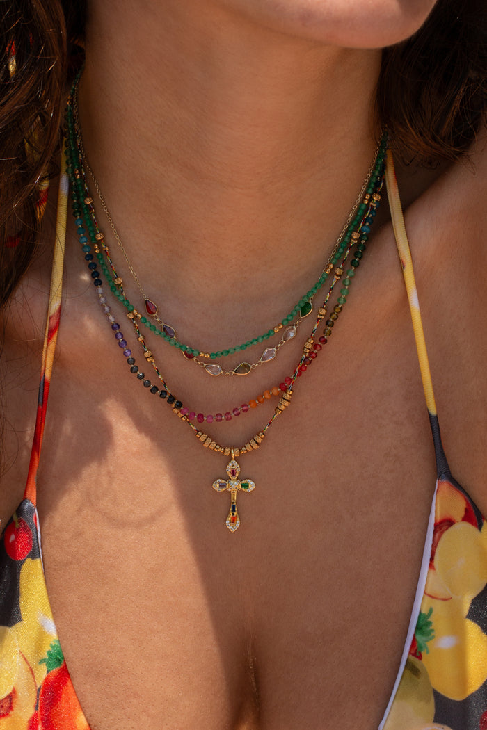 Caliente cross pendant on a twisted gold chain with beaded detail