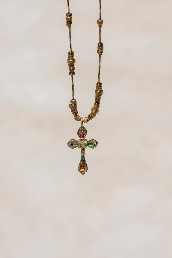 Detail of the jewel-tone stone settings across the Caliente cross pendant
