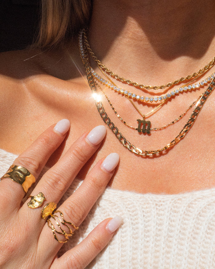 Model wearing the gold Carissa tennis necklace at the neckline