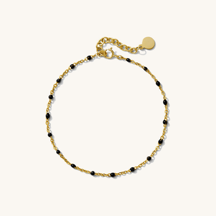 Close up of a chain bracelet with black beads on a white background