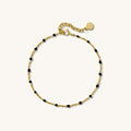 Close up of a chain bracelet with black beads on a white background