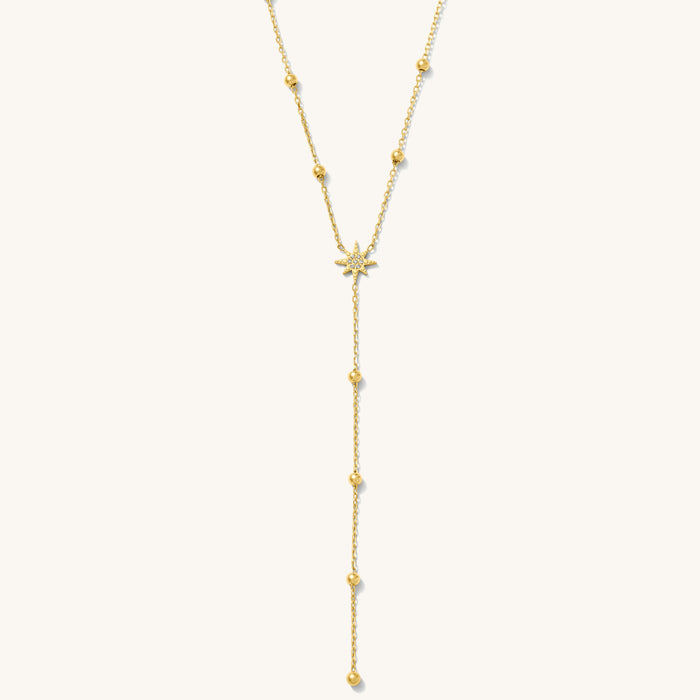 Close up of the gold Celeste lariat necklace on a white background
