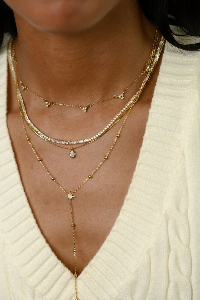 Close view of the gold Celeste lariat necklace on a white background